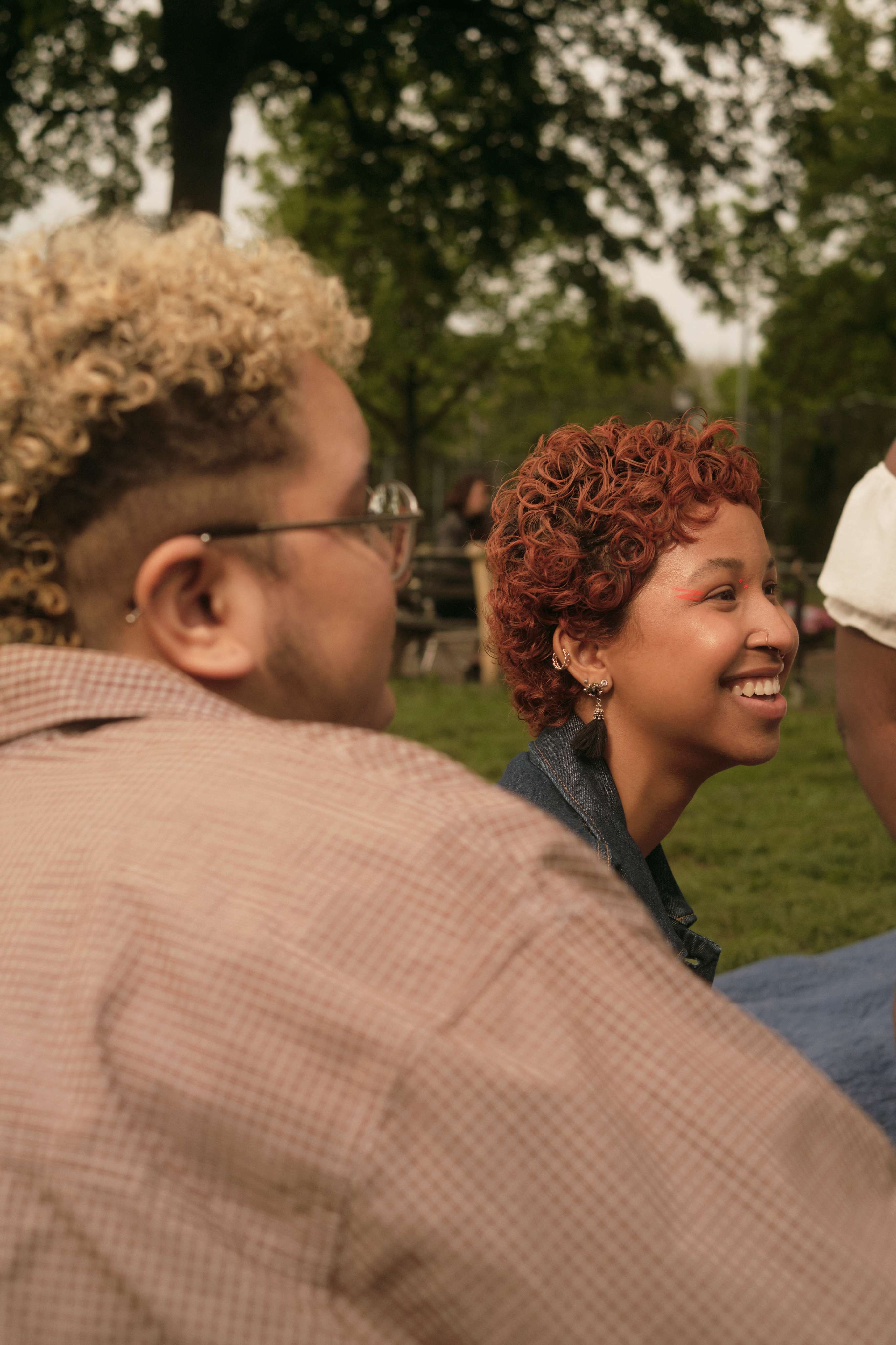a group of friends of varying genders hanging out in a park