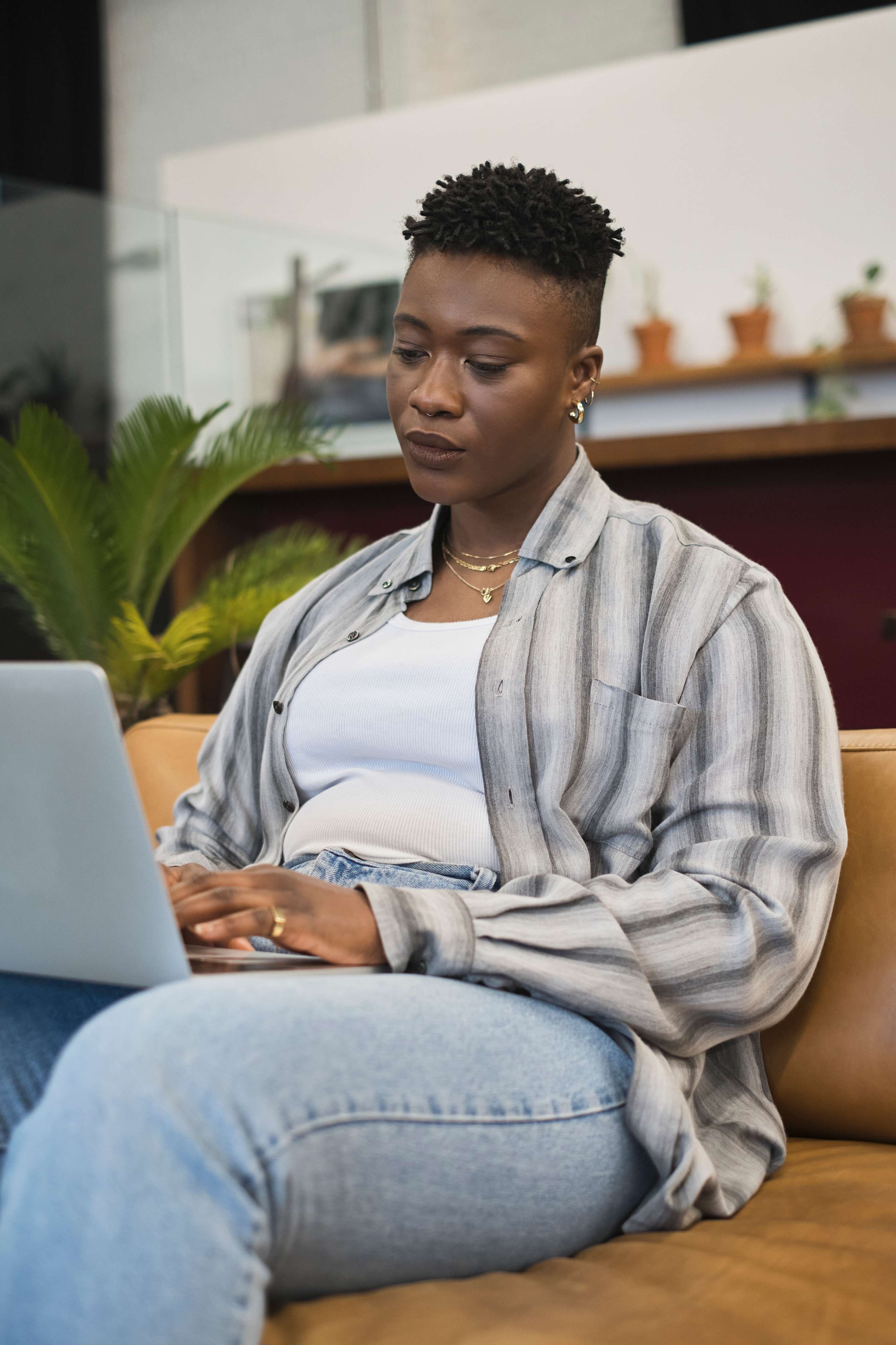 Home a non binary person using a laptop at work.