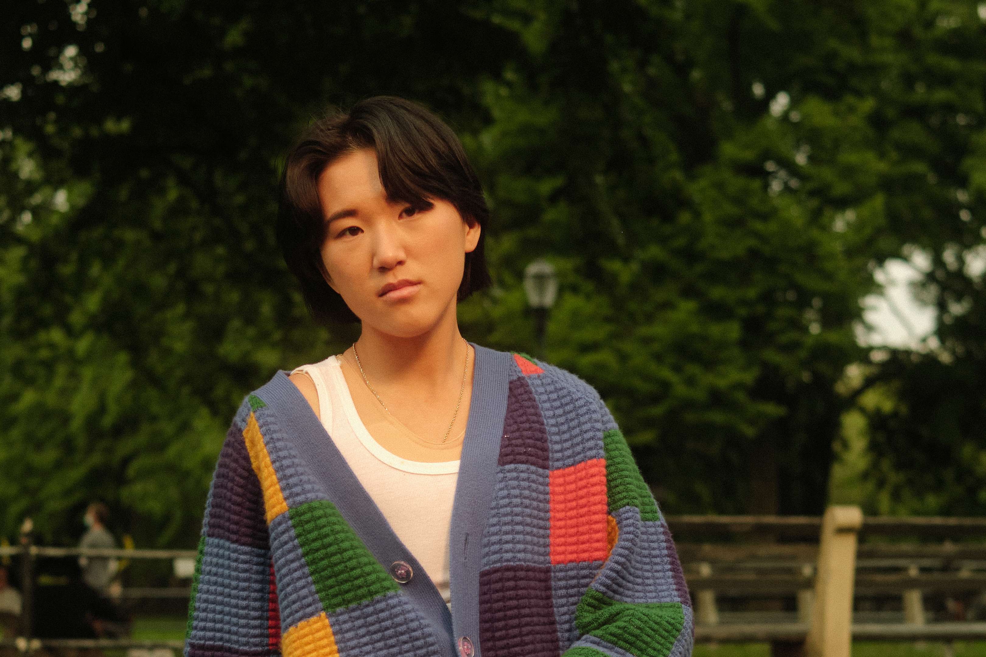 a non binary trans man sitting in a park